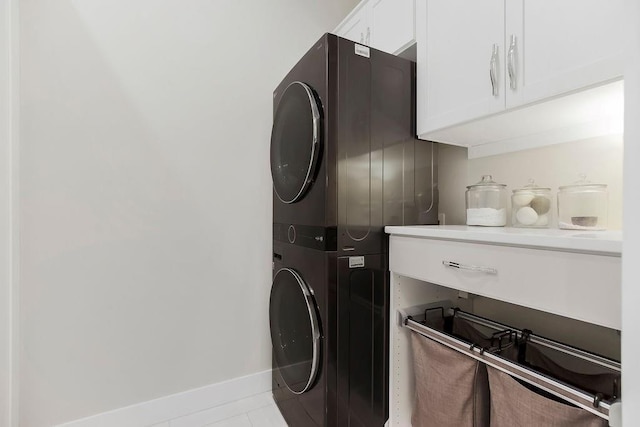 10300 W 174th St, Overland Park, KS 66221 - laundry room with stacked washer / drying machine, cabinet space, baseboards, and tile patterned floors