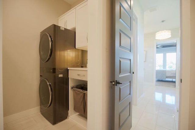 10300 W 174th St, Overland Park, KS 66221 - laundry room featuring stacked washer and clothes dryer, cabinet space, and baseboards