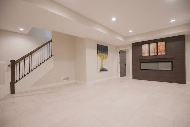 10300 W 174th St, Overland Park, KS 66221 - spare room with a glass covered fireplace, stairs, baseboards, and recessed lighting