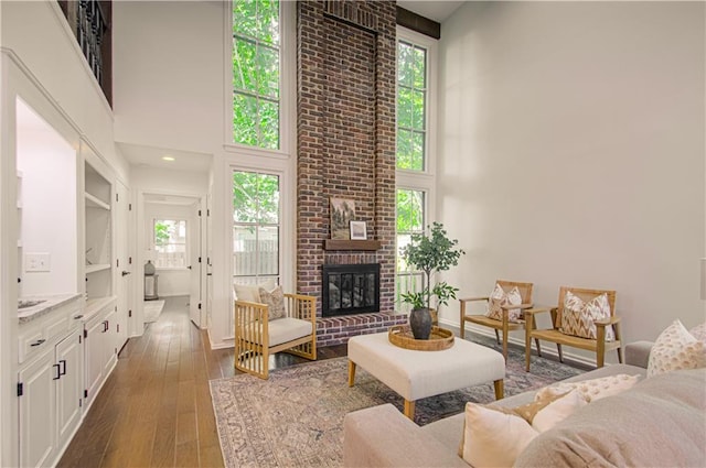 4300 W 112th St, Leawood, KS 66211 - living area featuring a high ceiling, healthy amount of natural light, dark wood finished floors, and a brick fireplace