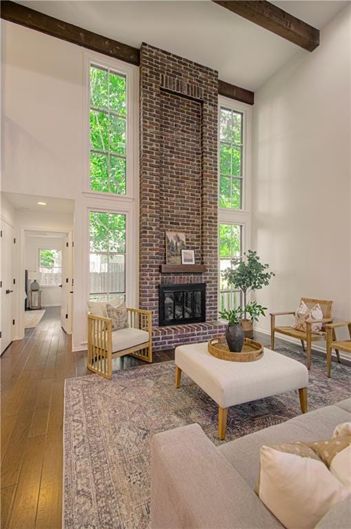 4300 W 112th St, Leawood, KS 66211 - living room with a towering ceiling, hardwood / wood-style floors, beamed ceiling, and a brick fireplace