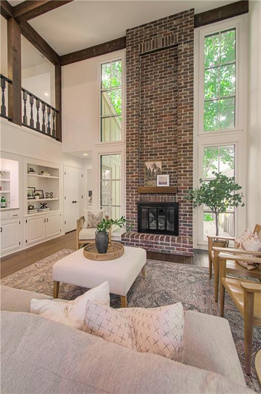 4300 W 112th St, Leawood, KS 66211 - living area featuring a towering ceiling, wood finished floors, plenty of natural light, a fireplace, and beamed ceiling