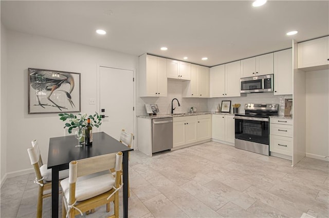 4300 W 112th St, Leawood, KS 66211 - kitchen with stainless steel appliances, a sink, tasteful backsplash, light stone countertops, and white cabinets