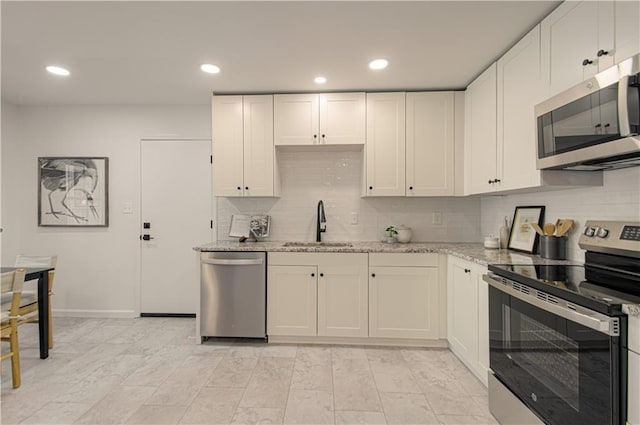 4300 W 112th St, Leawood, KS 66211 - kitchen with stainless steel appliances, a sink, tasteful backsplash, light stone counters, and white cabinets