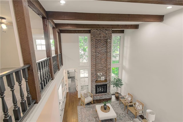 4300 W 112th St, Leawood, KS 66211 - living area with beamed ceiling, wood finished floors, a brick fireplace, and recessed lighting