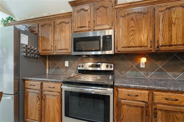 1611 NW Creekland Dr, Grain Valley, MO 64029 - kitchen with appliances with stainless steel finishes, tasteful backsplash, and brown cabinetry