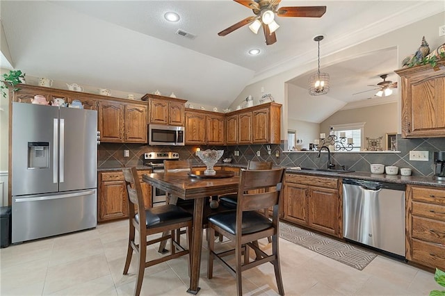 1611 NW Creekland Dr, Grain Valley, MO 64029 - kitchen featuring stainless steel appliances, a ceiling fan, a sink, lofted ceiling, and brown cabinets