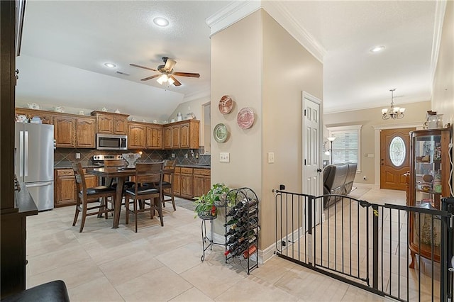 1611 NW Creekland Dr, Grain Valley, MO 64029 - kitchen with stainless steel appliances, ornamental molding, brown cabinetry, a ceiling fan, and decorative backsplash