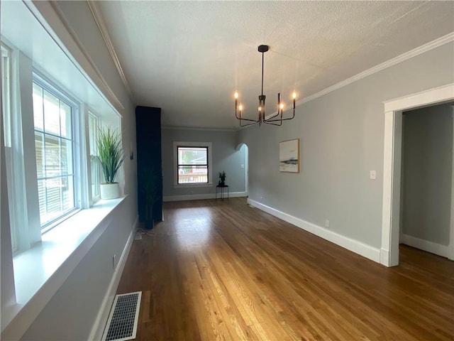 3208 E 31st St, Kansas City, MO 64128 - unfurnished dining area featuring arched walkways, ornamental molding, a chandelier, and wood finished floors