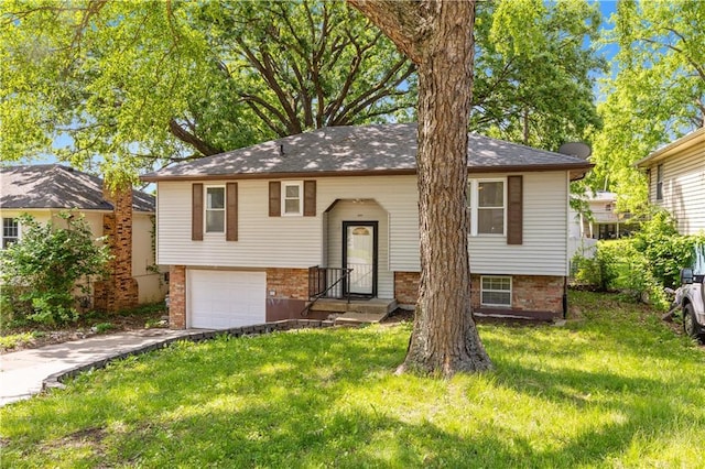 5317 NE 46th St, Kansas City, MO 64117 - raised ranch featuring concrete driveway, an attached garage, a front lawn, and brick siding
