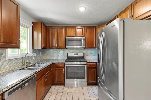 5317 NE 46th St, Kansas City, MO 64117 - kitchen with appliances with stainless steel finishes, a sink, tasteful backsplash, and brown cabinetry