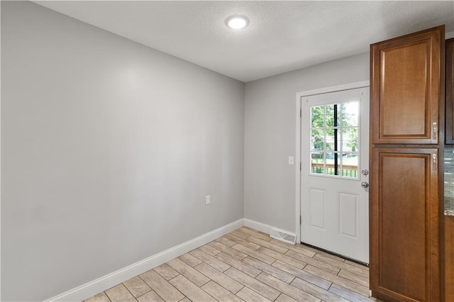 5317 NE 46th St, Kansas City, MO 64117 - doorway with baseboards, light wood finished floors, a textured ceiling, and recessed lighting