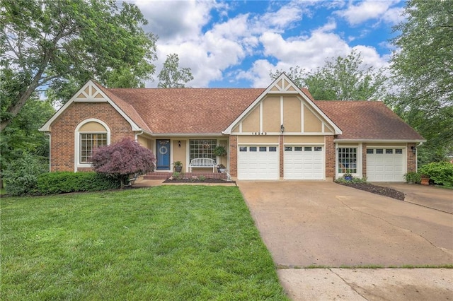 15243 Long St, Overland Park, KS 66221 - view of front facade featuring an attached garage, brick siding, a front yard, driveway, and stucco siding