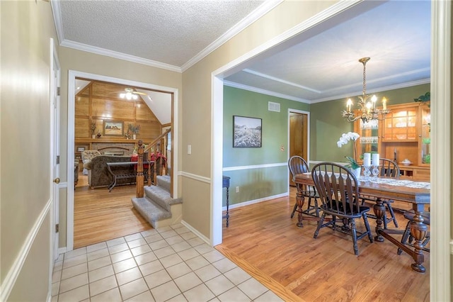 15243 Long St, Overland Park, KS 66221 - dining room with a chandelier, light tile patterned floors, stairway, ornamental molding, and a textured ceiling