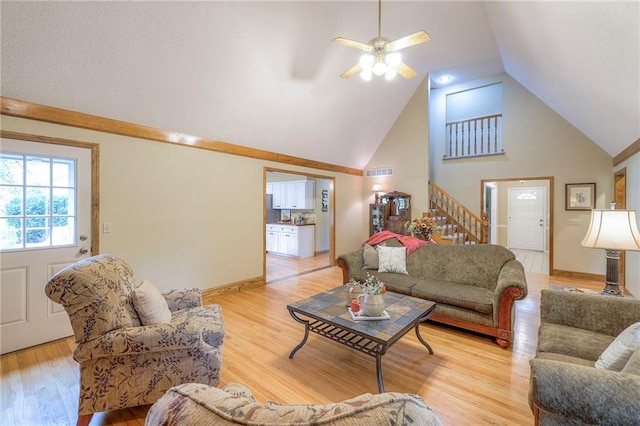 15243 Long St, Overland Park, KS 66221 - living room featuring stairs, light wood-type flooring, ceiling fan, high vaulted ceiling, and baseboards