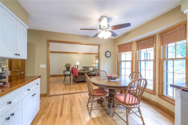15243 Long St, Overland Park, KS 66221 - dining room featuring light wood-type flooring, healthy amount of natural light, a ceiling fan, and baseboards