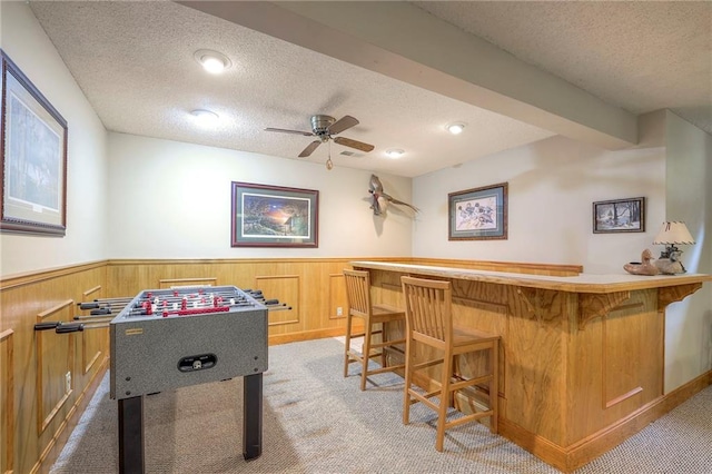 15243 Long St, Overland Park, KS 66221 - rec room with a textured ceiling, a bar, light colored carpet, wainscoting, and ceiling fan