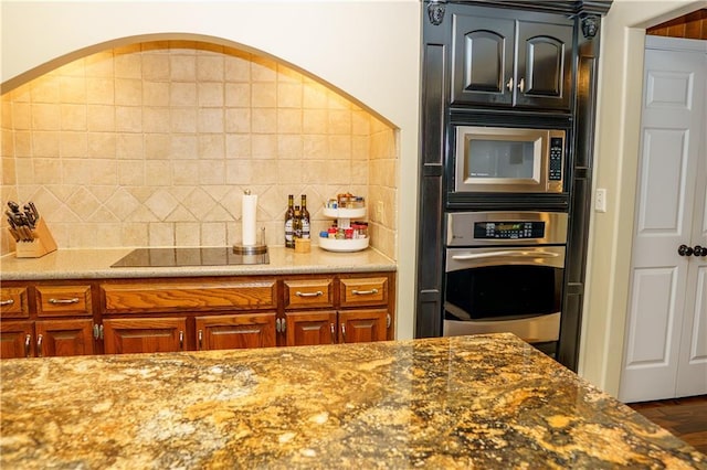 204 NW Redwood Ct, Lees Summit, MO 64064 - kitchen featuring stainless steel appliances, backsplash, dark stone counters, and wood finished floors