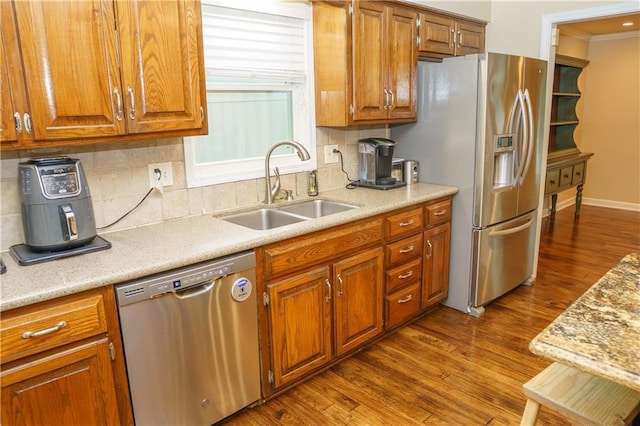 204 NW Redwood Ct, Lees Summit, MO 64064 - kitchen featuring appliances with stainless steel finishes, dark wood-type flooring, brown cabinetry, and light countertops