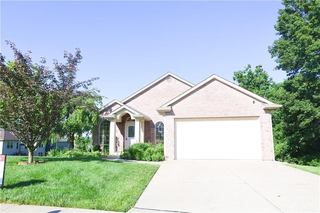 2404 Edmonds Ct, Columbia, MO 65203 - view of front of house featuring an attached garage, brick siding, concrete driveway, and a front yard