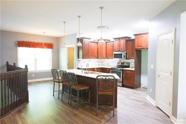 2404 Edmonds Ct, Columbia, MO 65203 - kitchen featuring appliances with stainless steel finishes, a sink, wood finished floors, and decorative backsplash