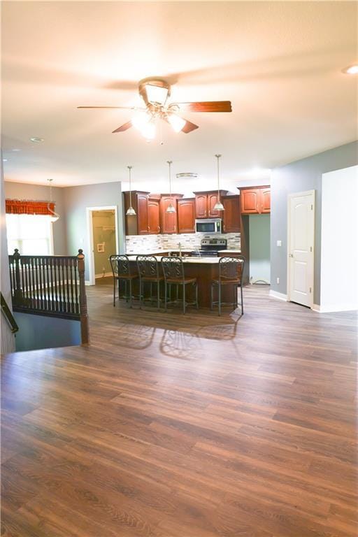 2404 Edmonds Ct, Columbia, MO 65203 - kitchen with appliances with stainless steel finishes, baseboards, a breakfast bar, ceiling fan, and dark wood-style floors
