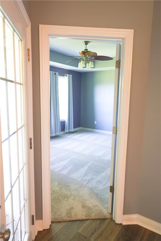 2404 Edmonds Ct, Columbia, MO 65203 - hallway featuring baseboards, wood finished floors, and carpet