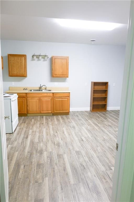 2404 Edmonds Ct, Columbia, MO 65203 - kitchen with a sink, white electric stove, light wood-style floors, and light countertops