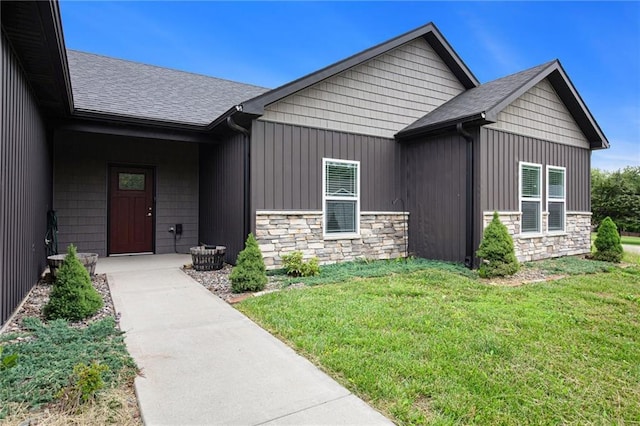 151 SE 225th Rd, Warrensburg, MO 64093 - view of exterior entry featuring stone siding, a yard, and board and batten siding