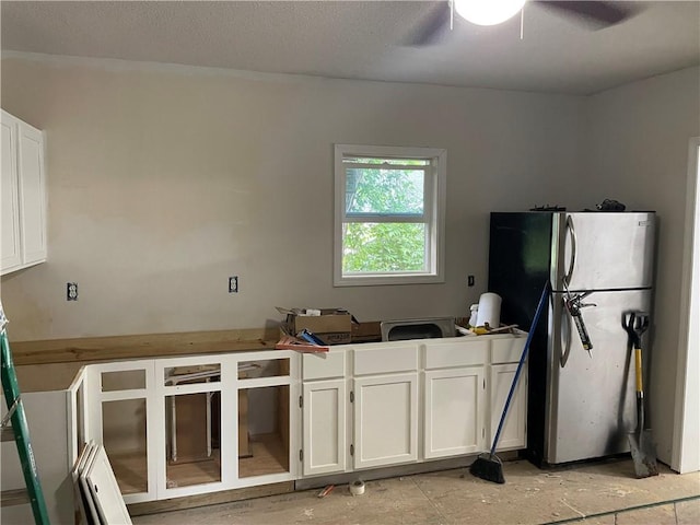 1226 10th Ave, Leavenworth, KS 66048 - kitchen featuring freestanding refrigerator, white cabinetry, and a ceiling fan