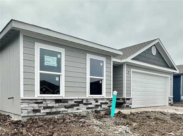 575 W Lanesfield St, Gardner, KS 66030 - view of home's exterior with an attached garage, stone siding, and dirt driveway