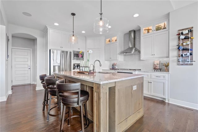 4313 Lakeview Ter, Basehor, KS 66007 - kitchen with wall chimney exhaust hood, appliances with stainless steel finishes, a sink, baseboards, and arched walkways