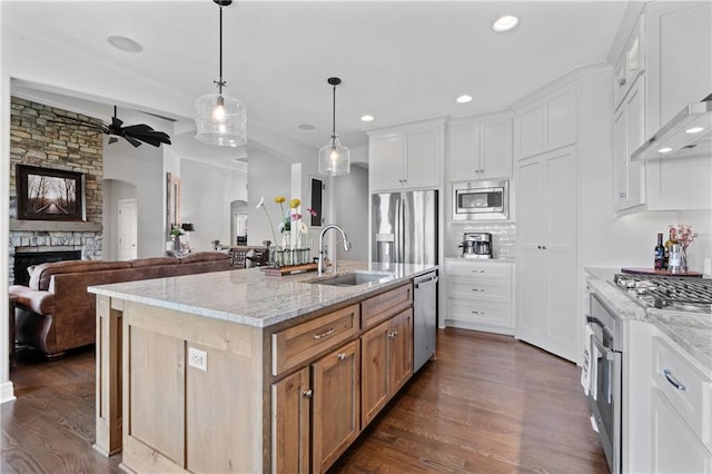 4313 Lakeview Ter, Basehor, KS 66007 - kitchen with a sink, appliances with stainless steel finishes, ceiling fan, a fireplace, and wall chimney range hood
