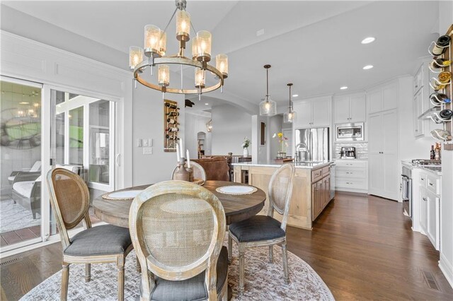 4313 Lakeview Ter, Basehor, KS 66007 - dining area with a chandelier, dark wood-type flooring, arched walkways, recessed lighting, and lofted ceiling