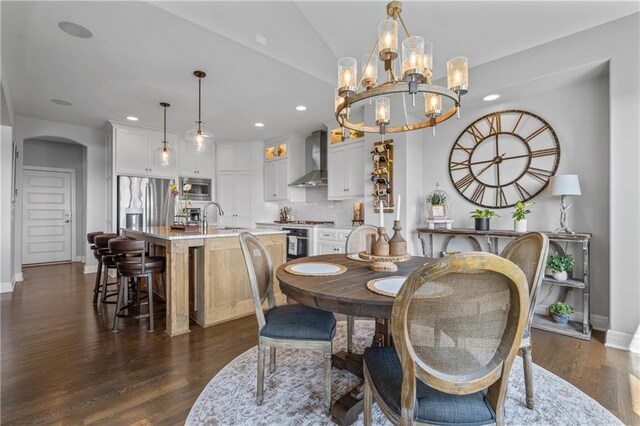 4313 Lakeview Ter, Basehor, KS 66007 - dining area featuring baseboards, a chandelier, arched walkways, recessed lighting, and dark wood-style floors