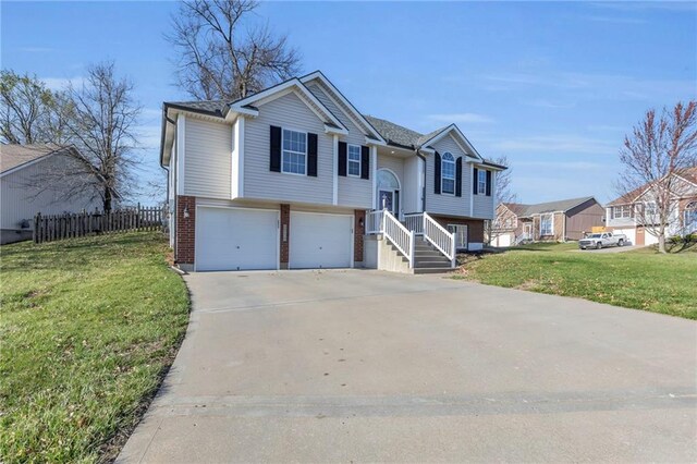 3708 N 112th St, Kansas City, KS 66109 - raised ranch featuring a garage, brick siding, driveway, and a residential view