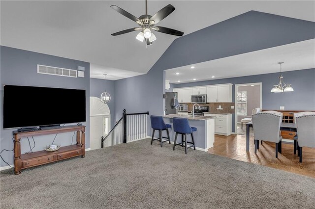 3708 N 112th St, Kansas City, KS 66109 - living room featuring a chandelier, a ceiling fan, light carpet, recessed lighting, and high vaulted ceiling