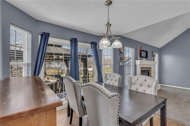 3708 N 112th St, Kansas City, KS 66109 - carpeted dining area with a glass covered fireplace, baseboards, and lofted ceiling