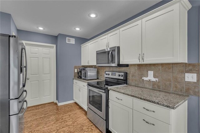 3708 N 112th St, Kansas City, KS 66109 - kitchen with stainless steel appliances, light wood-style flooring, white cabinetry, and recessed lighting