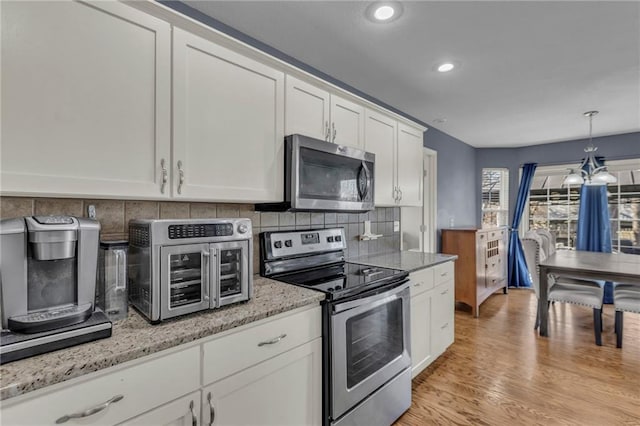 3708 N 112th St, Kansas City, KS 66109 - kitchen featuring appliances with stainless steel finishes, decorative backsplash, white cabinets, light wood-type flooring, and recessed lighting
