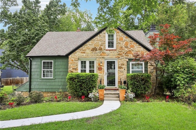4208 W 48th St, Roeland Park, KS 66205 - tudor home with stone siding, a chimney, a front lawn, and a shingled roof
