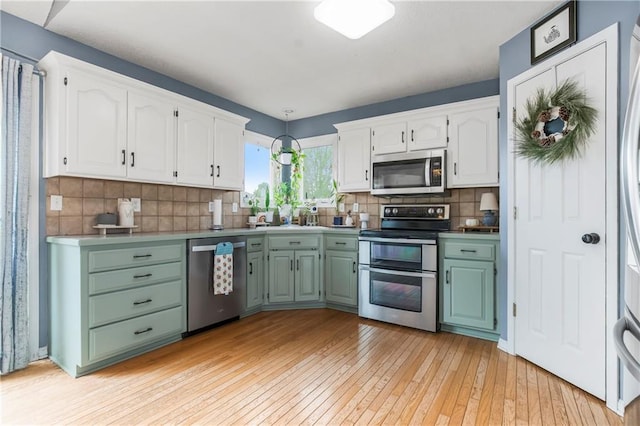 616 N Winwood Ter, Gardner, KS 66030 - kitchen with stainless steel appliances, white cabinets, light wood finished floors, and backsplash