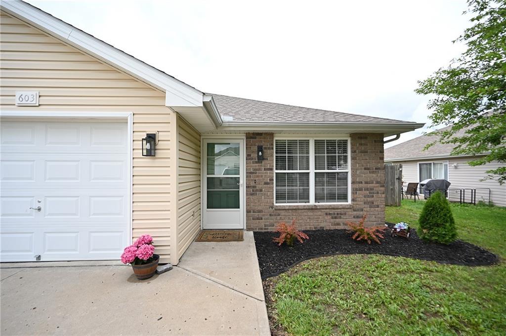 603 Terry Dr, Pleasant Hill, MO 64080 - property entrance featuring brick siding, a garage, and a shingled roof