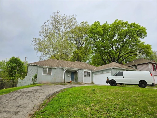 10538 Cleveland Ave, Kansas City, MO 64137 - single story home featuring a garage, a front yard, and asphalt driveway