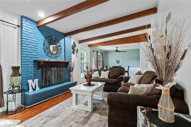 10538 Cleveland Ave, Kansas City, MO 64137 - living area with beamed ceiling, wood finished floors, a ceiling fan, and a fireplace