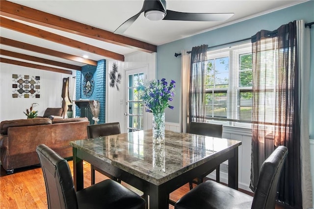 10538 Cleveland Ave, Kansas City, MO 64137 - dining space featuring ceiling fan, beamed ceiling, light wood-style flooring, and a decorative wall