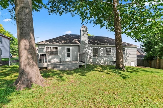 10538 Cleveland Ave, Kansas City, MO 64137 - rear view of house featuring a chimney and a wooden deck