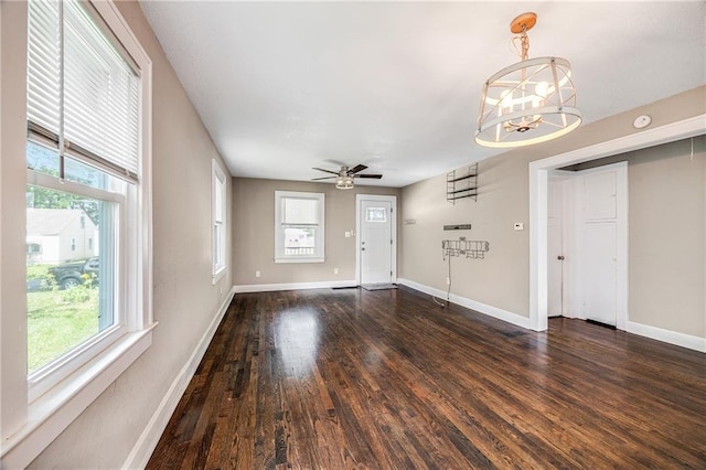 1025 S Park Ave, Independence, MO 64050 - unfurnished living room with dark wood finished floors, plenty of natural light, a ceiling fan, and a chandelier
