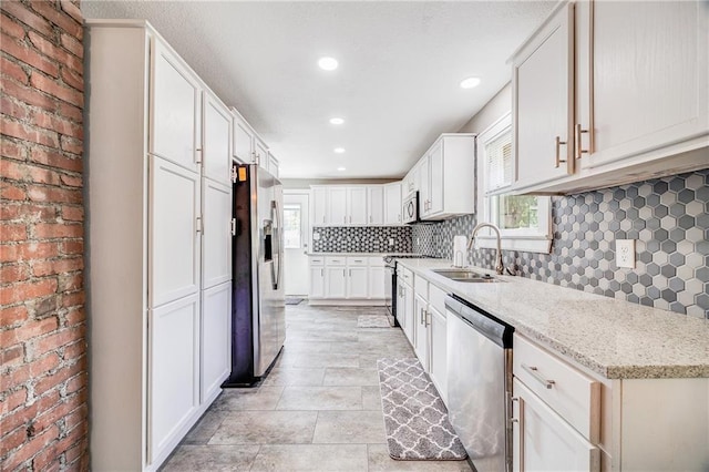 1025 S Park Ave, Independence, MO 64050 - kitchen featuring stainless steel appliances, healthy amount of natural light, backsplash, recessed lighting, and light stone counters