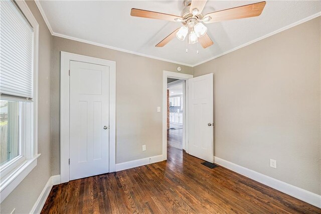 1025 S Park Ave, Independence, MO 64050 - unfurnished bedroom featuring wood finished floors, multiple windows, crown molding, and a ceiling fan